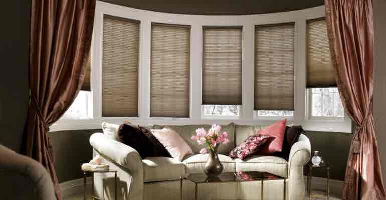 Adjustable honeycomb shades in living room bow window.